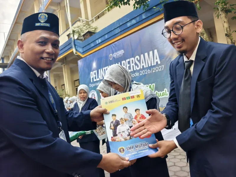 Kepala SMP Mutual Magelang, Ahmad Haryanto, menyerahkan penghargaan kepada guru berprestasi.