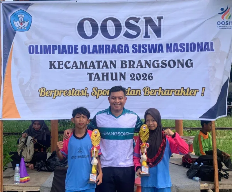 Siswa SDN 2 Tunggulsari bersama Guru PJOK Maula menunjukkan piala usai meraih juara dalam ajang O2SN Brangsong 2026 cabang Kids Athletics.
